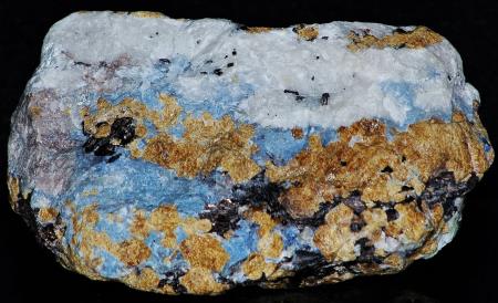 Blue willemite, minor light purple willemite, calcite, andradite garnet, and hendricksite mica